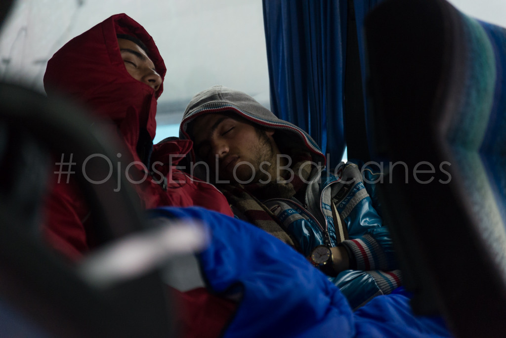 Dos refugiados duermen en uno de los autobuses. Foto: Pablo Ibáñez. 