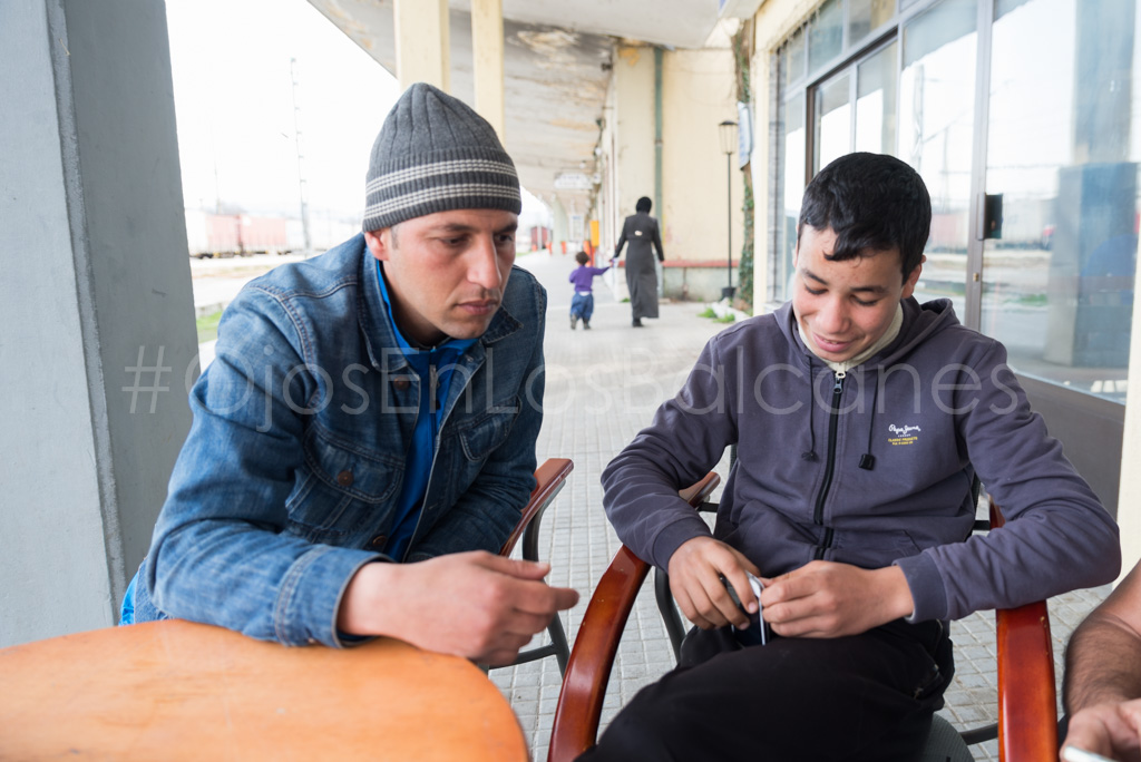 Abou Baker juega con su móvil junto a otro joven marroquí en la estación de Idomeni. Sus amigos ya estaban en Serbia. Foto: Pablo Ibáñez. 