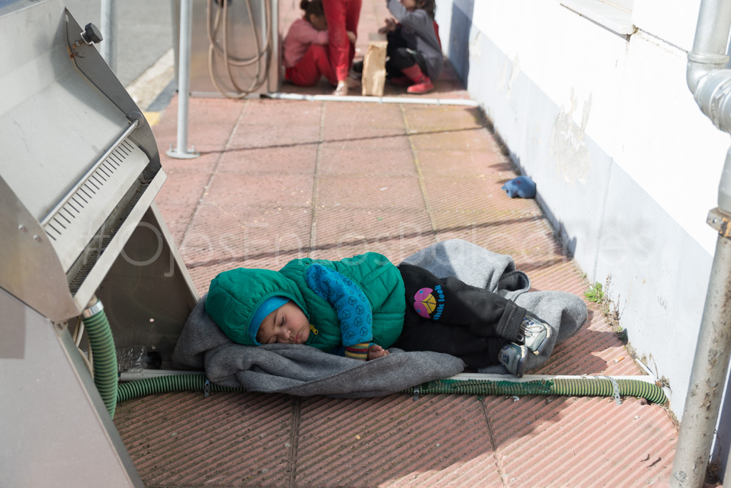 El cansancio del camino. Un niño duerme junto al tunel de lavado de Polykastro. Foto: Pablo Ibáñez.