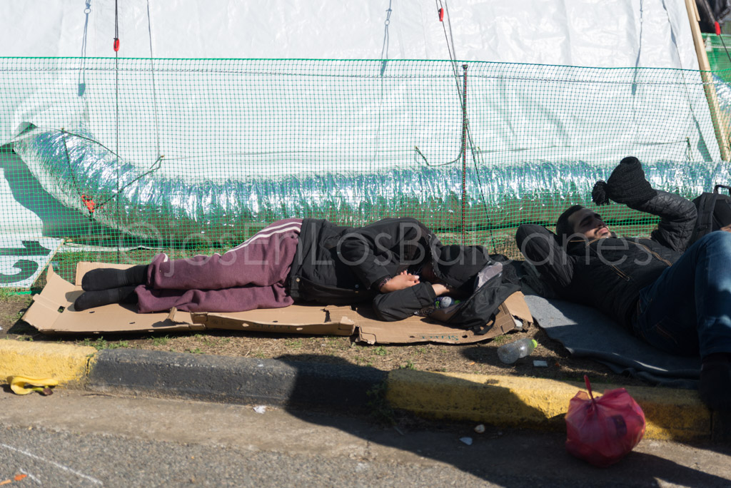 El cansancio del camino. Descansando en el asfalto de la estación de Polykastro. Foto: Pablo Ibáñez.