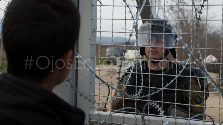 Un policía macedonio observa una de las protestas en el campo de Idomeni. Foto: Pablo Ibáñez.